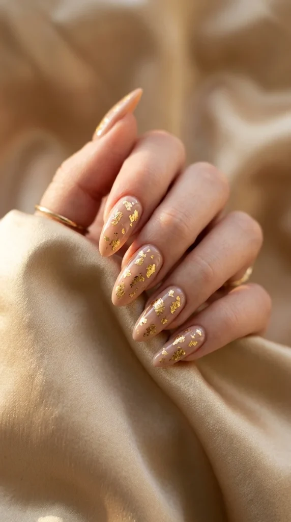 glazed nude gold foil nails wedding guest almond warm nude scattered gold foil champagne silk warm light modern luxury