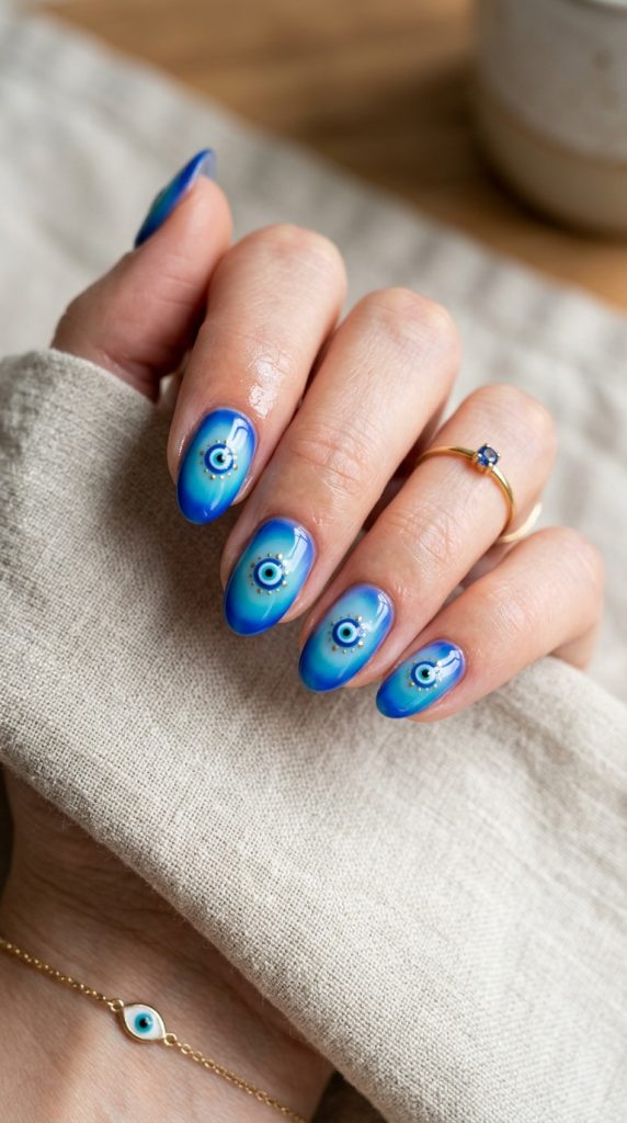 Evil eye aura nails with a blue glow and evil eye motif