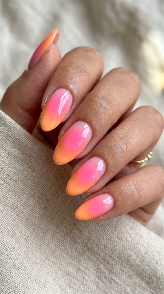 Neon aura nails with bright glowing pink and orange
