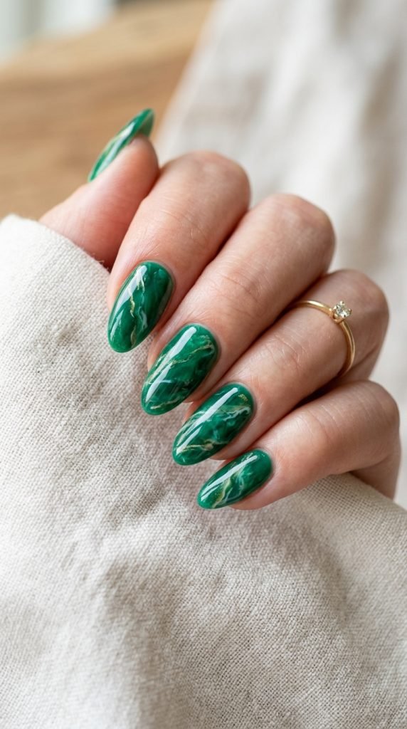 Emerald green dip nails showing rich jewel tone and luxurious finish