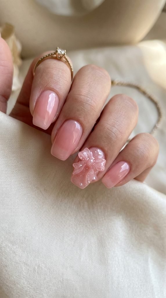 Translucent pink nails with 3D raised bow accent detail