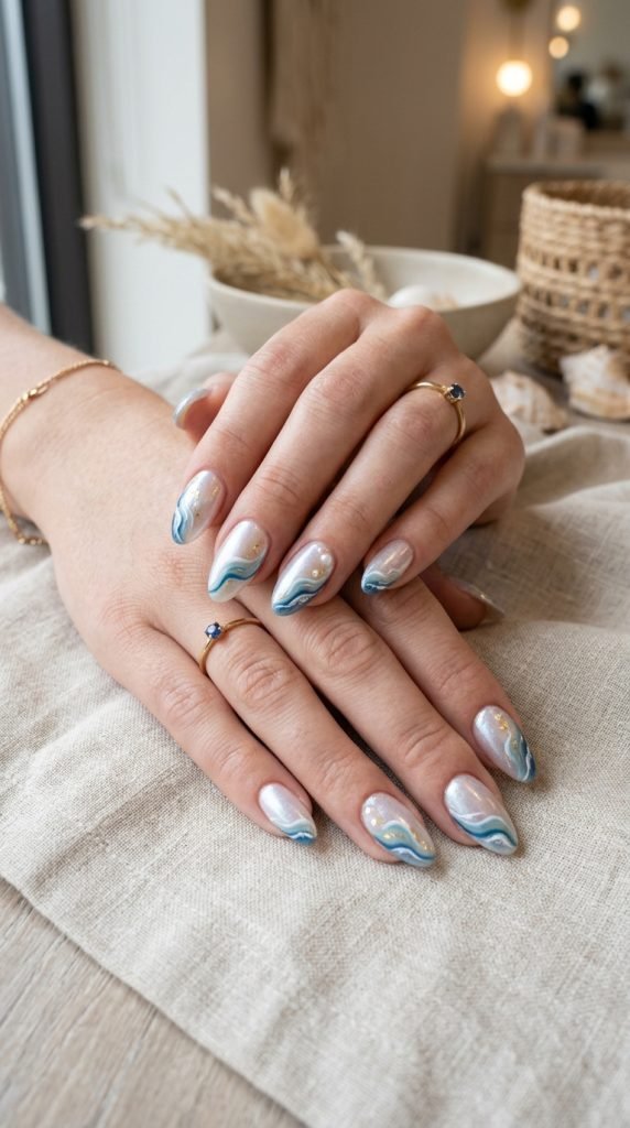 Pearl white nails with ocean accents showing elegant beach aesthetic